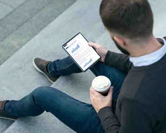 man looking at tablet to track exchange rates